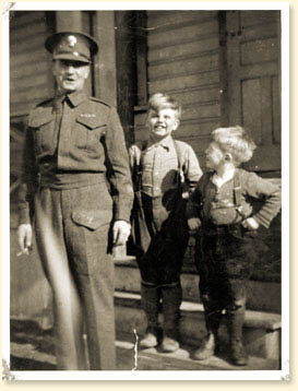 CSM John R. Osborn standing with his two sons on the steps of a house