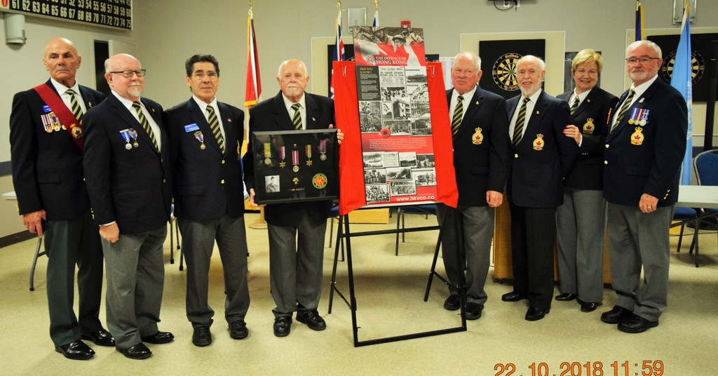President Bob Collins on right and High River Legion Executive with plaque, also holding Veteran George Auld’s medals